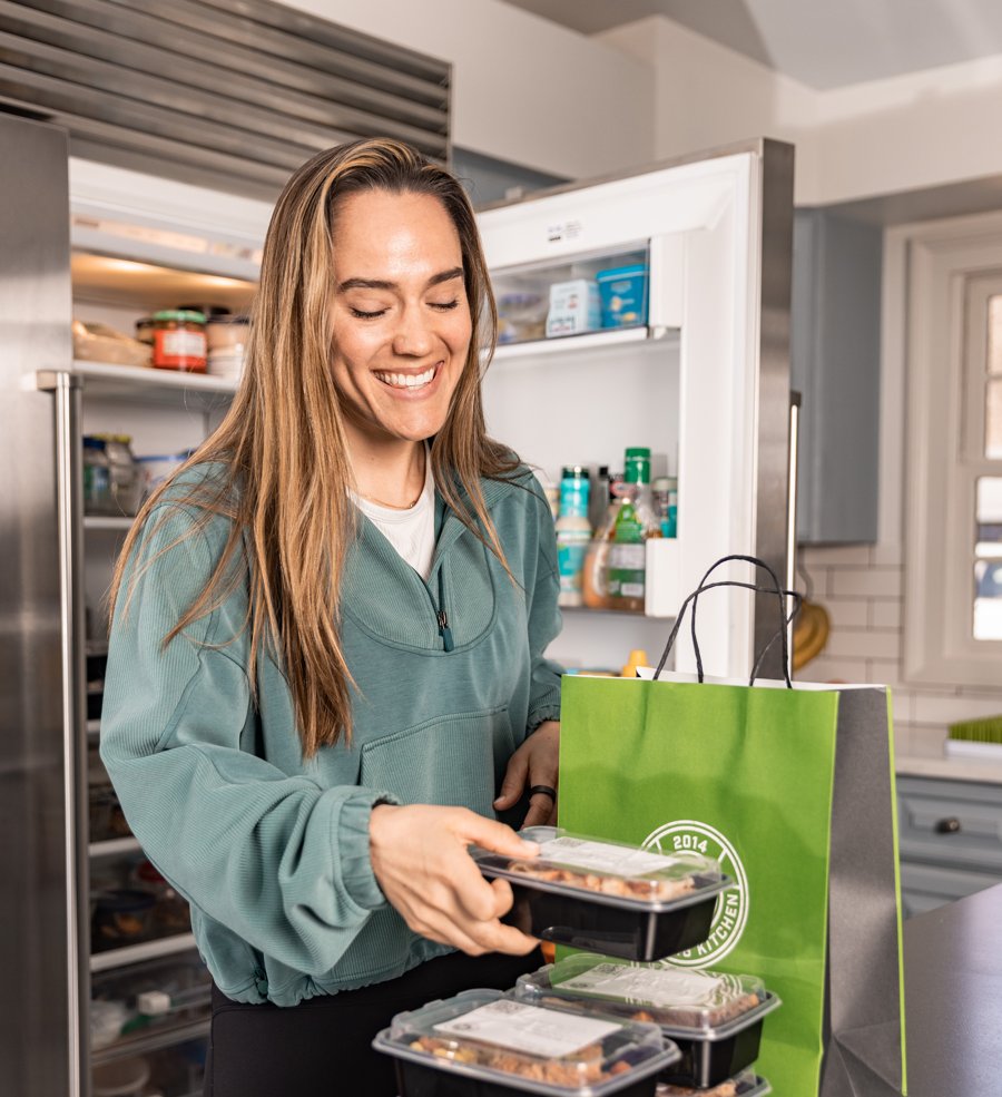A customer stocking her fridge with Strong Kitchen meals